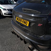 a shot of a black car, with its license plate visible on the back